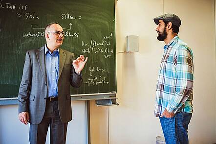 Foto: Dozent und Studierende diskutieren während einer Lehrveranstaltung