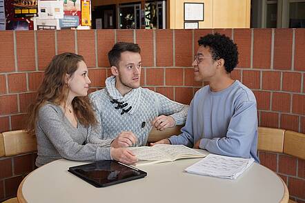 Foto: Studierende der Hochschule für Musik Freiburg sitzen an einem Tisch und diskutieren über Musikstücke      