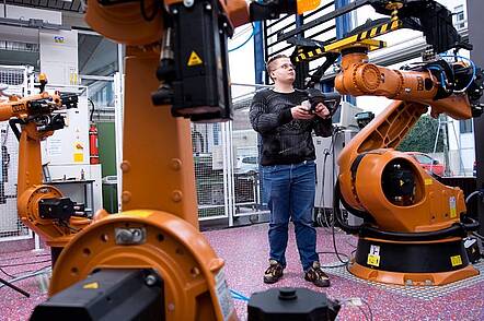 Foto: Studierender des Fachbereichs Maschinenbau programmiert Roboter