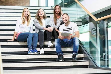 Foto: Studierende auf einer Treppe im Gebäude der Hochschule Worms