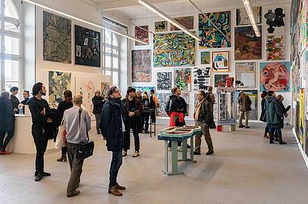 Foto: Besucher machen einen Ausstellungsrundgang in der Hochschule für Grafik und Buchkunst Leipzig 