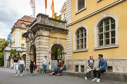 Foto: Studierende sitzen vor dem Hochschulgebäude der Technischen Hochschule Würzburg-Schweinfurt