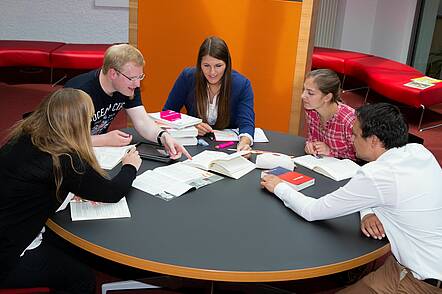Foto: Studierende sitzen an einem Tisch und lernen gemeinsam