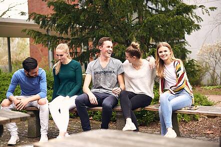 Foto: Studierende während gemeinsamer Pause auf dem Campus