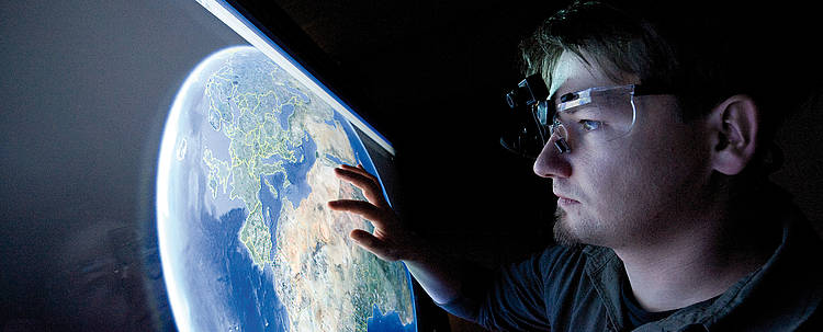 Student betrachtet Projektion der Erde (Foto: Fachhochschule Aachen/Thilo Vogel)