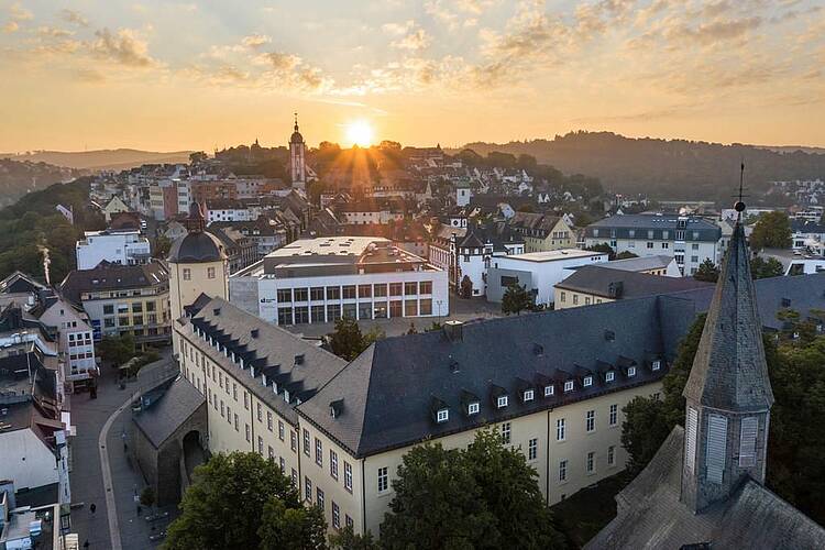 Foto: Blick von oben auf den Campus Unteres Schloss der Universität Siegen im Sonnenuntergang.