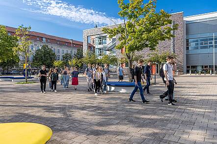 Foto: Erstsemesterstudierende gehen in Gruppen über den Campus der Europa-Universität Viadrina und unterhalten sich