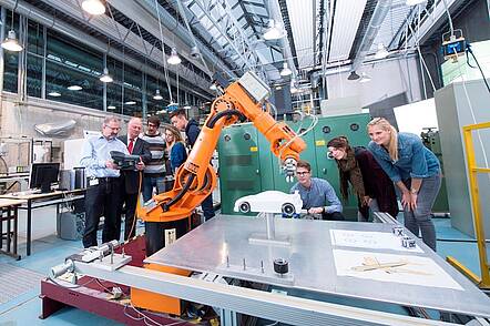Foto: Studierende betrachten einen Roboterarm im Maschinenbaulabor der Hochschule Esslingen.