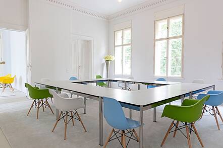 Seminarraum der Health and Medical University Potsdam (HMU) (Foto: PRAMI) Foto: Blick in einen Seminarraum mit Tischen, die in einem Rechteck zusammenstehen, und bunten Stühlen