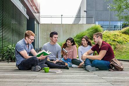 Foto: Studierende der Technischen Universität Dresden sitzen vor dem Informatikgebäude