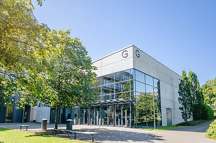 Foto: Blick über den Campus auf das Hochschulgebäude der Universität Paerborn mit seiner verglasten Front