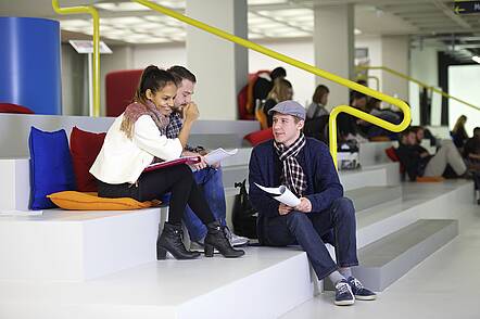 Foto: Studierende diskutieren im Foyer der Bibliothek