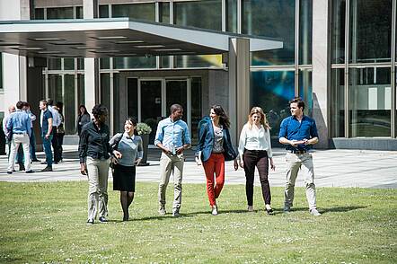 Foto: Studierende der ESMT European School of Management and Technology gehen über den Campus und unterhalten sich.