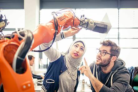 Foto: Studierende bei technischer Überprüfung eines Roboters