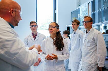 Foto: Studierenden folgen den Erläuterungen eines Dozenten im Labor der Universität. 