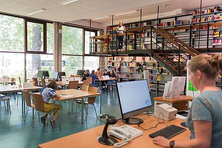 Foto: Studierende sitzen im großen Lesesaal der Bibliothek der Evangelischen Hochschule Berlin