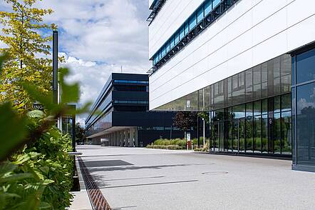 Foto: Blick über den Campus auf die Fassade zweier Hochschulgebäude der Hochschule Neu-Ulm