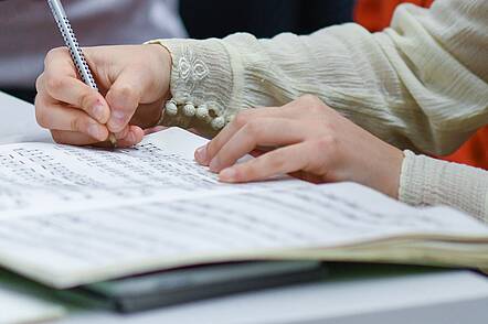 Foto: Studierende notiert Kommentare in Noten.