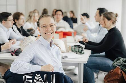 Foto: Studierenden der FAU an einem langen Tisch.