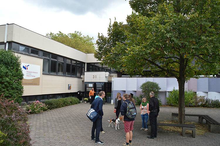 Lehrgebäude (Foto: Theologische Hochschule Reutlingen) Foto: Studierende vor dem Eingang zum Lehrgebäude der Theologischen Hochschule Reutlingen