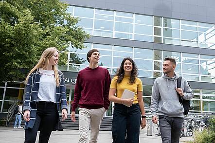 Foto: Studierende gehen über den Campus vor dem Hörsaalgebäude der Universität Marburg