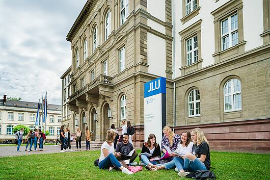 Foto: Studierende vor dem Hauptgebäude der Justus-Liebig-Universität Gießen