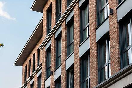 Foto: Außenansicht der Exponential University mit ihrer Fassade aus rot-braunem Backstein