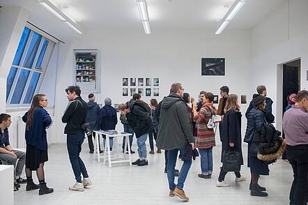 Foto: Besucher betrachten eine Ausstellung an der Hochschule für Grafik und Buchkunst Leipzig