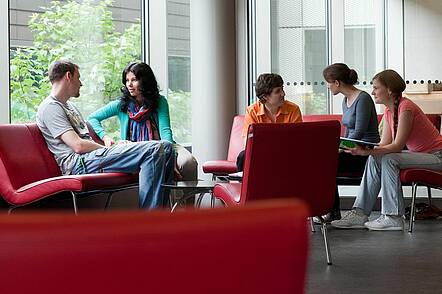 Foto: Studierende der Universität Heidelberg sitzen zusammen und unterhalten sich. 