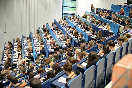 Foto. Studierende hören im Audimax der Universität Trier eine Vorlesung
