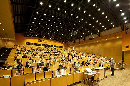 Foto: Studierende sitzen in einem Hörsaal und hören eine Vorlesung
