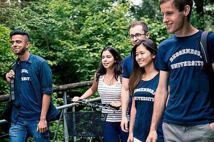 Foto: Studierende der Technischen Hochschule Deggendorf gehen durch einen Park.