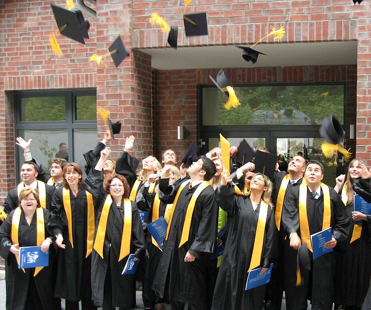 Foto: Diplomanden werfen während der Absolventenfeier Ihre Hüte.