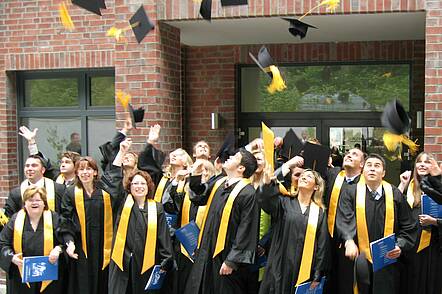 Foto: Diplomanden werfen während der Absolventenfeier Ihre Hüte.