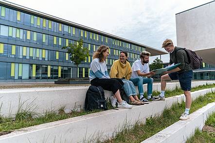 Studierende auf dem Campus der Technischen Hochschule Würzburg-Schweinfurt (Foto: THWS / Jonas Kron) Foto: Eine Gruppe Studierender sitzt auf dem Campus der Technischen Hochschule Würzburg-Schweinfurt und unterhält sich