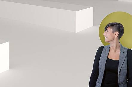 Foto: Eine Absolventin des Studiengangs Digital Film Design steht vor einer digitalen Projektion.