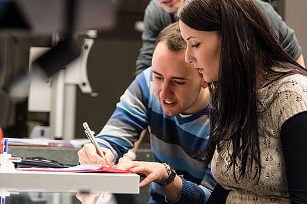 Foto: Studierende arbeiten an einem Tisch