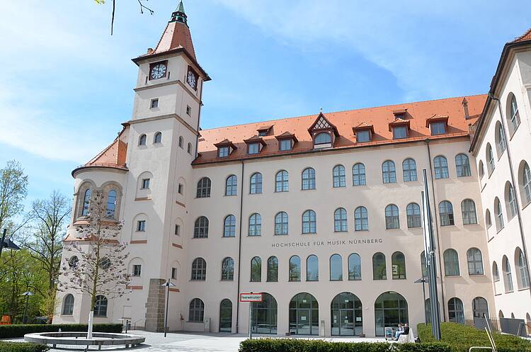 Foto: Blick auf die schöne Fassade der Hochschule für Musik Nürnberg mit Turm und Rundbogenfenstern
