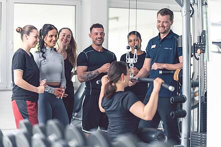 Foto: Studierende trainieren gemeinsam im Fitnessbereich.