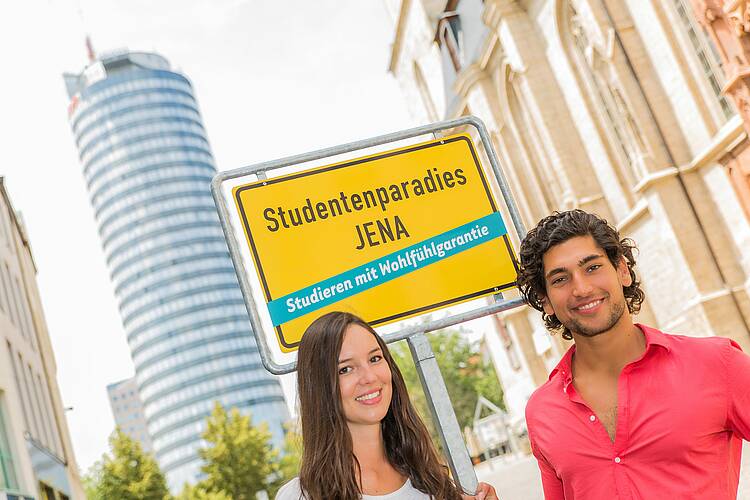 Foto: Studierende der Universität Jena stehen vor einem Ortsschild