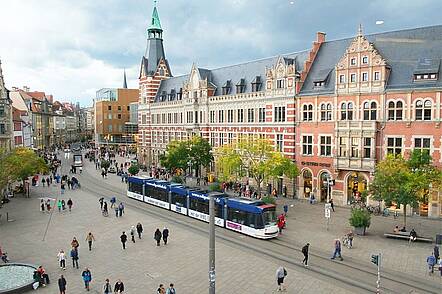 Foto: Blick über einen Platz, den eine Straßenbahn quert, auf das ehemalige Hauptpostamt Erfurt