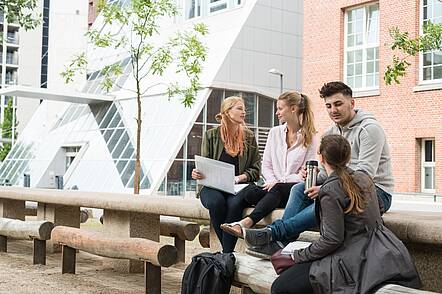 Foto: Studierende sitzen auf dem Campus Berliner Tor der HAW und unterhalten sich