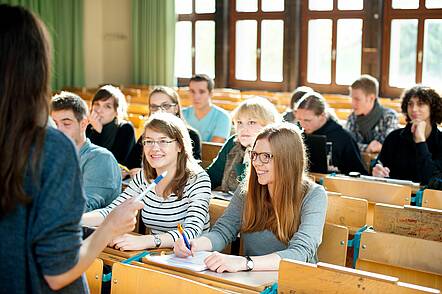 Foto: Studierende sitzen in einem Hörsaal und folgen eine Vorlesung