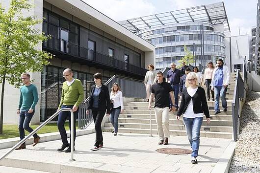 Foto: Studierende an der FernUniversität in Hagen gehen über eine Treppe auf dem Campus