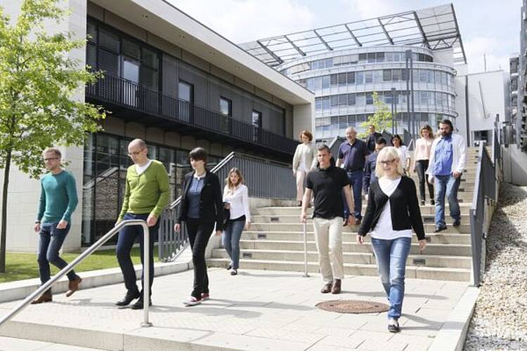 Foto: Studierende an der FernUniversität in Hagen gehen über eine Treppe auf dem Campus