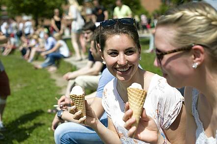 Foto: Studentinnen der Universität Bayreuth sitzen im Park und essen Eis