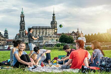 Foto: Studierende der Technische Universität Dresden sitzen an der Elbe