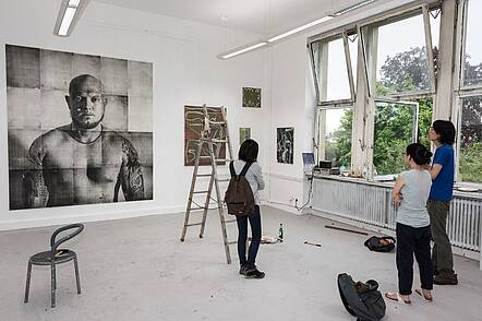 Studierende (Foto: Staatliche Akademie der Bildenden Künste Karlsruhe) Foto: Studierende diskutieren ihre Arbeiten im Atelier