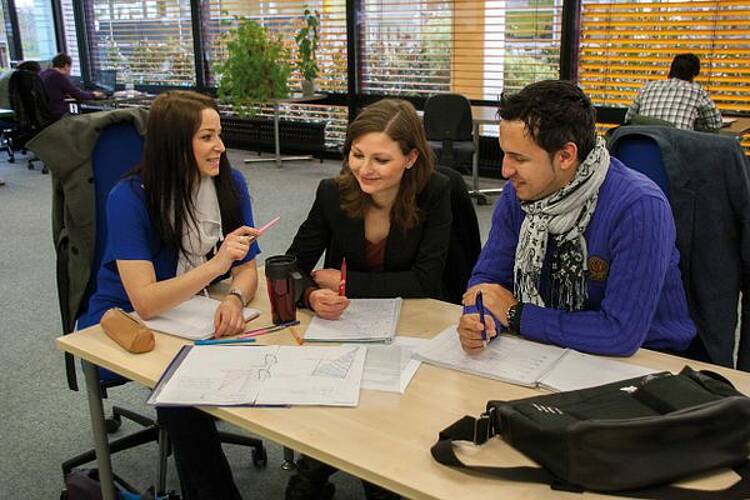 Foto: Eine Lerngruppe von 3 Studierenden an einem Tisch