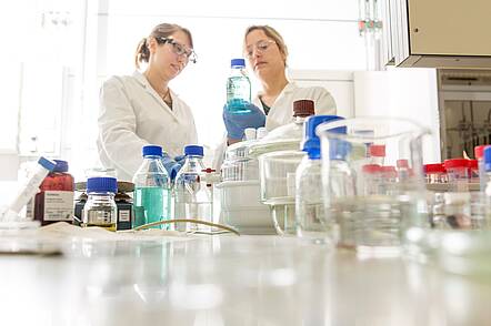 Foto: Studierende arbeiten im Labor des Instituts für Funktionelle Grenzflächen mit Reagenzgläsern 